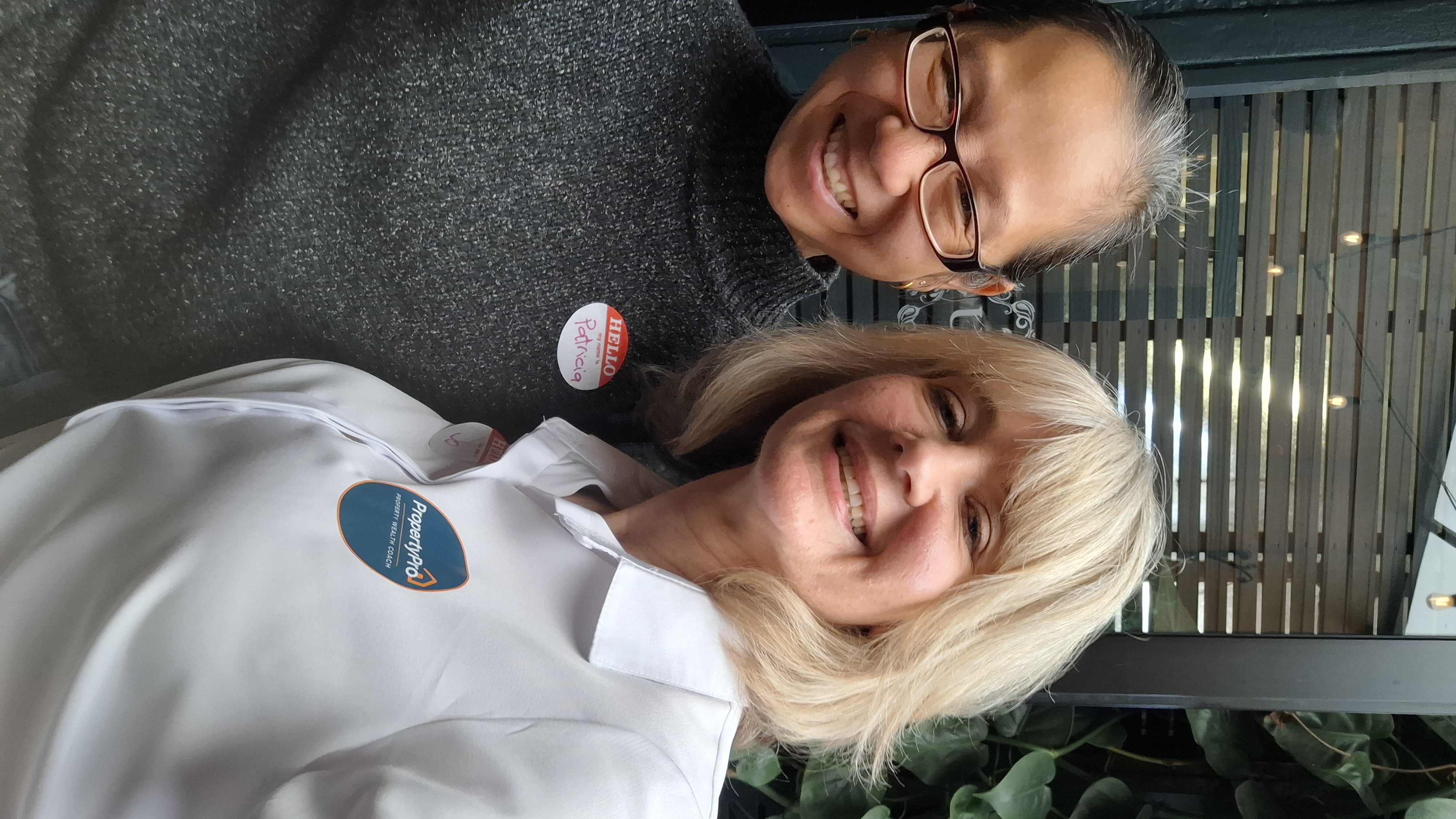 Two attendees smiling for a selfie on the deck at The Union Post
