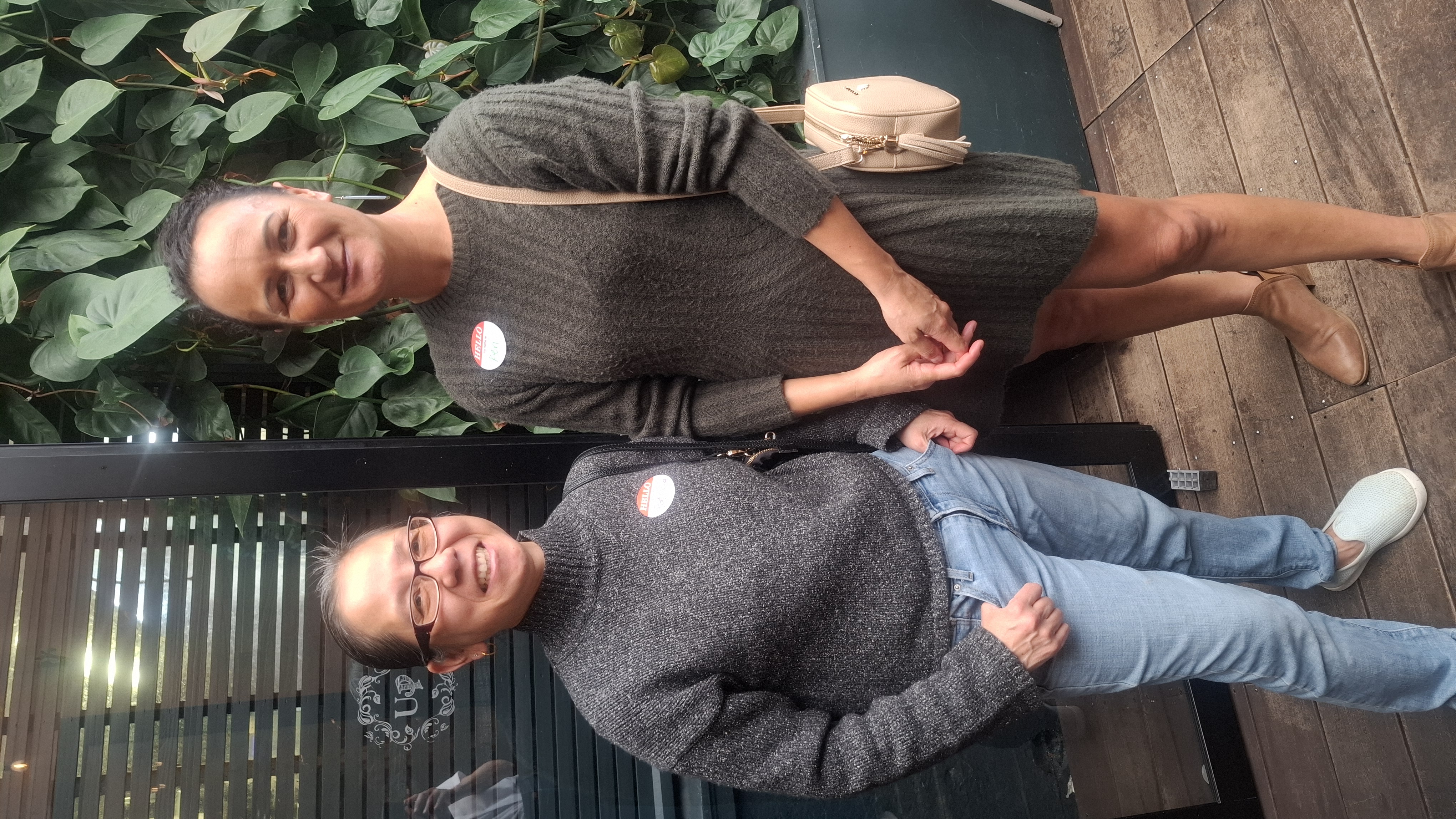 Two attendees with name badges by the plant wall at The Union Post