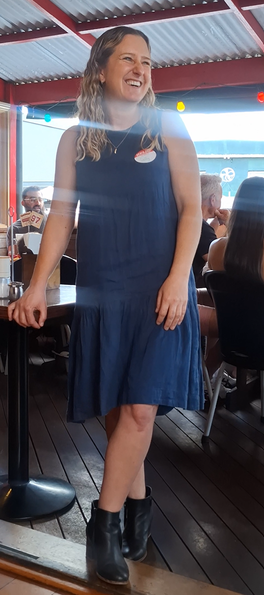 A guest in a navy dress laughing on the cafe deck